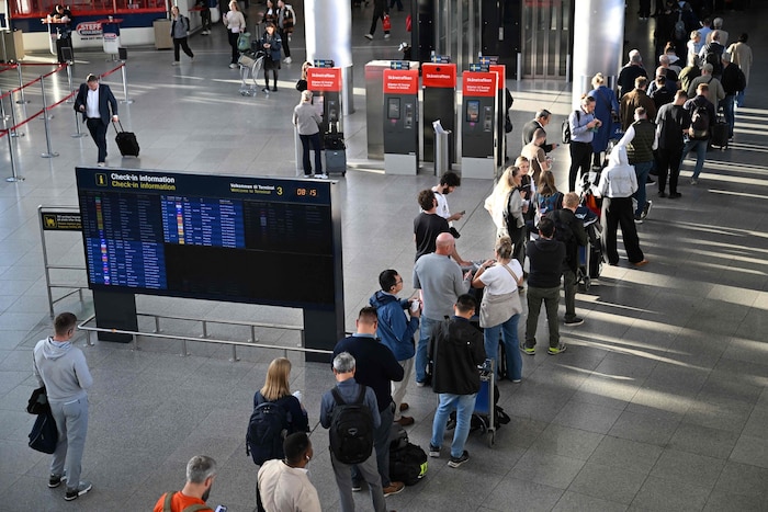 Passagiere stehen in einer Schlange, um an der Servicestelle des Flughafens Kopenhagen neue ...