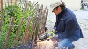 Neubaus Bezirksvorsteher Markus Reiter (Grüne) flext eine Schlüsselbox weg.