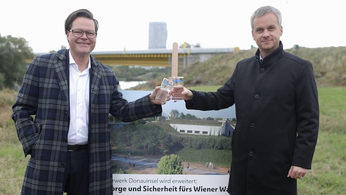 Czernohorszky und Hellmeier stoßen mit einem Glas Wasser auf den Baustart des Wasserwerks an.