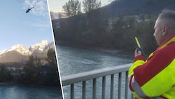 Auf der Fußgängerbrücke in Telfs/Pfaffenhofen haben sich Wasserretter postiert.