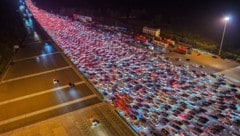 Autofahrer warten darauf, die Mautstelle auf einer Schnellstraße in Chuzhou zu passieren, ...