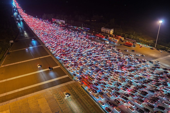 Autofahrer warten darauf, die Mautstelle auf einer Schnellstraße in Chuzhou zu passieren, ...