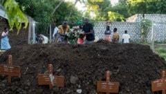 Familienmitglieder und Verwandte legen Blumen auf das Grab des fünfjährigen Seith Ngala, seiner ...