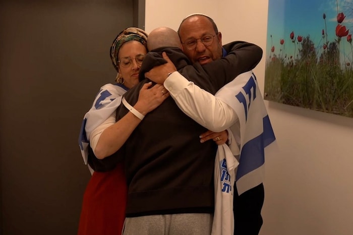 Eitan Mor is embraced by his parents.