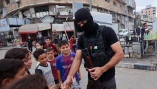 Ein Hamas-Mitglied umringt von Kindern im Gazastreifen