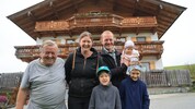 Hans Praschberger (li.) mit Martin Gstir und seiner Familie vor dem Hof, der durch ihr ...