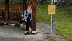 Anna wartet an der Haltestelle auf den Bus.
