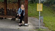 Anna wartet an der Haltestelle auf den Bus.