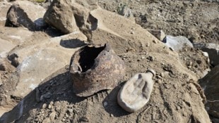 Eine verbeulte Feldflasche und ein beschädigter Helm lassen die Gräuel des Zweiten Weltkrieges ...