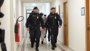 Drei Angeklagte werden schwer bewacht aus der U-Haft vorgeführt.