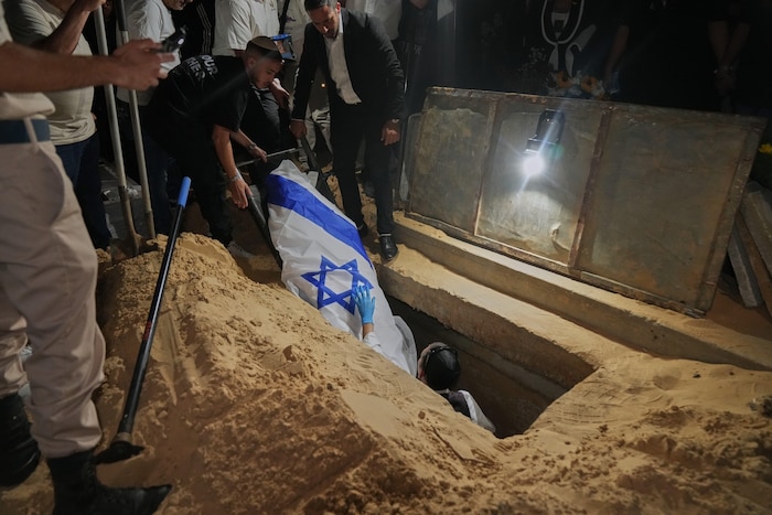 Verwandte und Freunde senken den Leichnam der getöteten israelischen Geisel Eitan Levi.