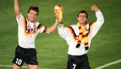 Pierre Littbarski mit Lothar Matthäus und dem WM-Pokal.