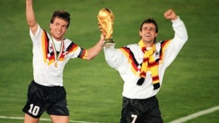 Pierre Littbarski mit Lothar Matthäus und dem WM-Pokal.