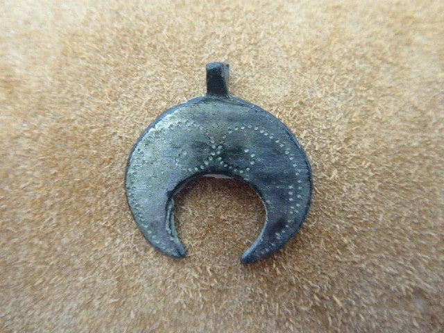 Lunula, halbmondförmiger Schmuck, oft als Amulett getragen, auch als Pferdeschmuck verwendet.