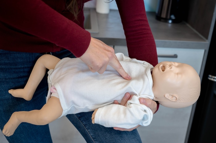 Bei Säuglingen wird mit zwei Fingern auf die Mitte des Brustbeins gedrückt.