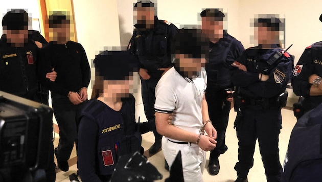 The main defendants, who are accused of sexual offenses, are brought out of custody under heavy ...