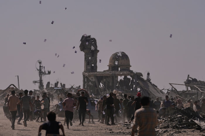 Bewohner des Gazastreifens fangen Flugblätter, die von einer israelischen Drohne abgeworfen ...