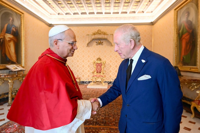 Leo XIV. und Charles III. schütteln sich die Hände.