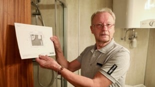 Walter H. mit dem Grundriss seines Badezimmers, das kaum zwei Mal zwei Meter misst. 