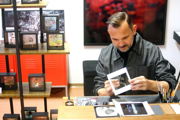 Präzise Handarbeit: Gerd Winkler beim Einsetzen einer Figur in den Holzrahmen