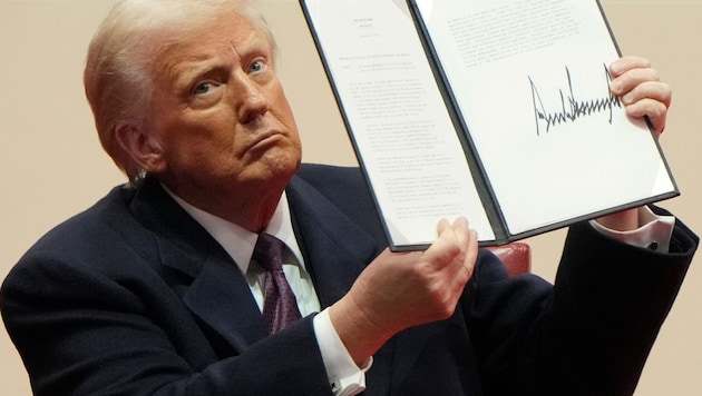 US-Präsident Trump präsentiert stolz seine Unterschrift.