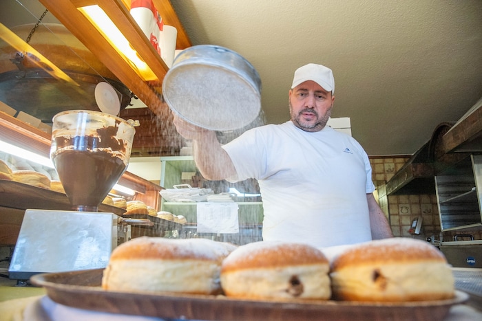 Nachdem die Füllung (Marillenmarmelade, Nougat- oder Vanillecreme) händisch in die Krapfen ...