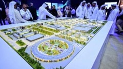 Besucher der Abu Dhabi International Petroleum Exhibition begutachten ein Modell des größten ...