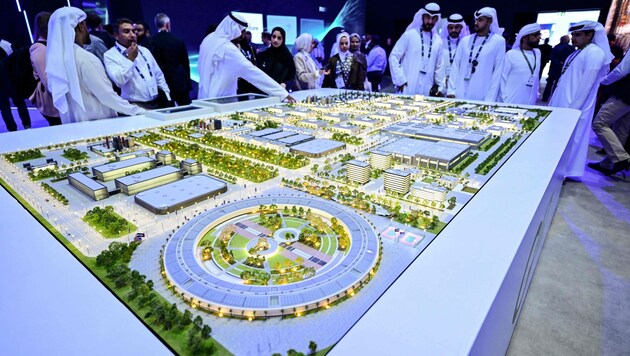 Besucher der Abu Dhabi International Petroleum Exhibition begutachten ein Modell des größten ...