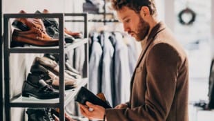 Wird dieser Mann den Schuh im Geschäft kaufen oder online bestellen?