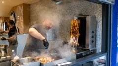 Ein Mitarbeiter bereitet das Fleisch für einen Calamari-Kebab im Restaurant „Pescobar“ zu