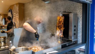 Ein Mitarbeiter bereitet das Fleisch für einen Calamari-Kebab im Restaurant „Pescobar“ zu