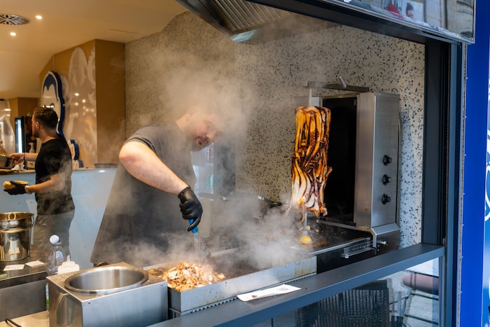 Ein Mitarbeiter bereitet das Fleisch für einen Calamari-Kebab im Restaurant „Pescobar“ zu