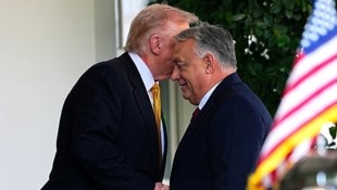 Trump flüstert Orbán ins Ohr.