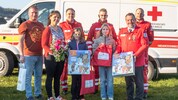 Die junge Lebensretterin Fiona (4. v. li.) und ihre Familie erhielten Besuch vom Roten Kreuz. ...