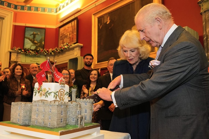 König Charles schneidet seine Torte an – sehr zum Vergnügen der Gäste im Hintergrund. Queen ...