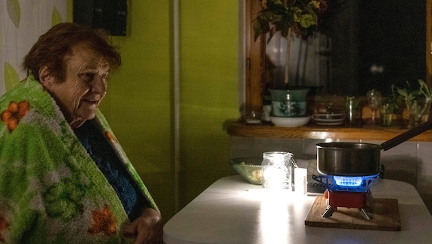 Während eines Blackouts kocht eine Bewohnerin von Kiew ihr Essen auf einem Gaskocher. Ständige ...