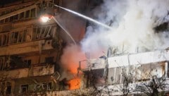 Feuerwehrleute löschen das Feuer, nachdem eine Drohne während eines nächtlichen Drohnenangriffs ...