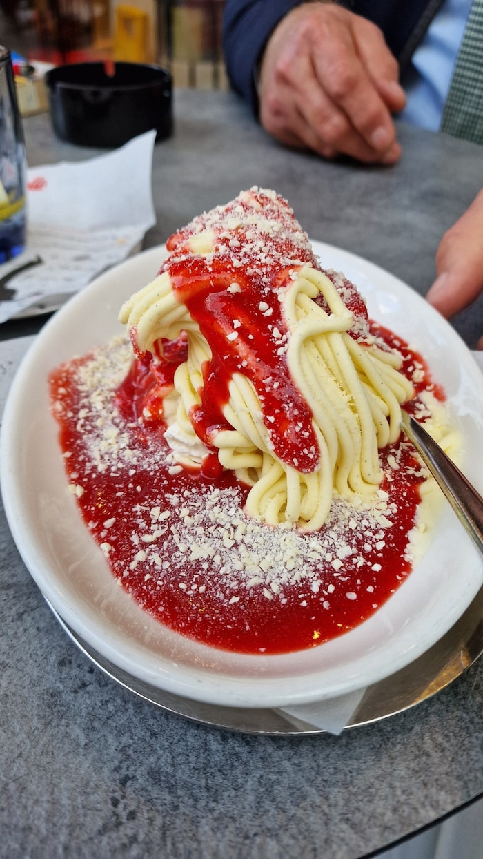 Spaghetti-Eis – das Original: Vanilleeis wird auf ein Bett aus Schlagobers und Erdbeerpürree ...