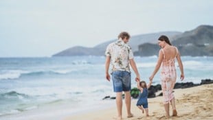 Die junge Familie am Strand in Hawaii.