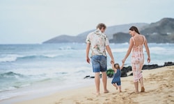 Die junge Familie am Strand in Hawaii.