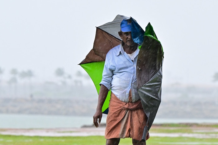 Ein Mann kämpft sich in Colombo durch das Unwetter.