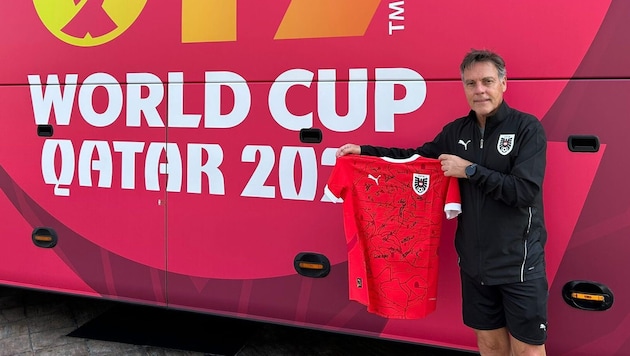 Trainer Hermann Stadler vor dem Teambus und mit den Unterschriften seiner Youngsters