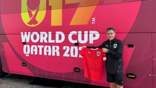 Trainer Hermann Stadler vor dem Teambus und mit den Unterschriften seiner Youngsters.