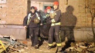 Rettungskräfte bergen in der Nacht Menschen aus einem getroffenen Wohnhaus.