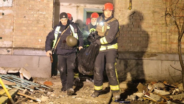 Rettungskräfte bergen in der Nacht Menschen aus einem getroffenen Wohnhaus.