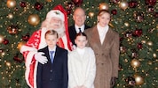 Die Fürstenfamilie posiert mit dem Weihnachtsmann vor dem beleuchteten Weihnachtsbaum.