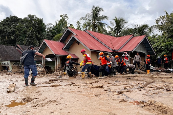 Einsatzkräfte tragen den Körper eines Flutopfers.