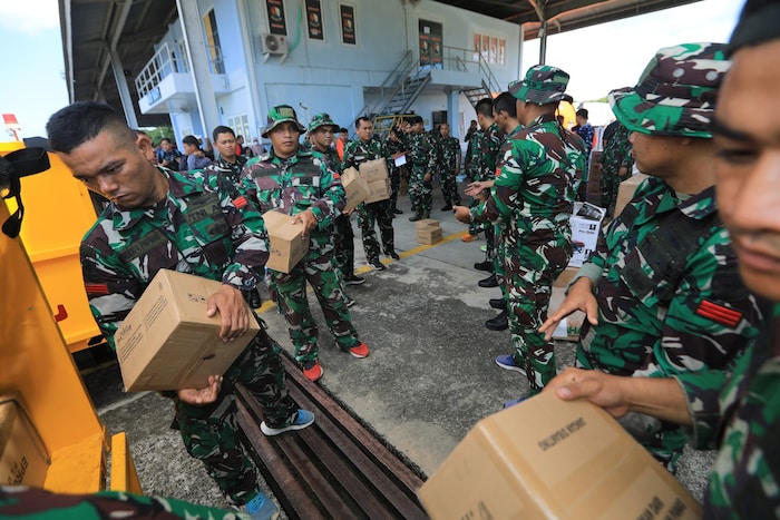 Indonesische Soldaten laden Hilfsgüter ein.