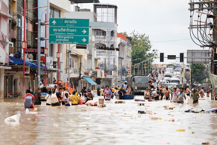 Menschen in der Provinz Songkhla waten durchs Wasser.