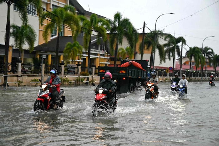 Mopeds fahren auf den überfluteten Straßen in Malaysia.